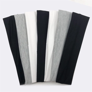 Detailed stack of athletic sweatbands in black, white, and grey cotton blend fabric