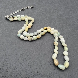 Detailed shot of irregular natural stone beads and stainless steel clasp on a necklace