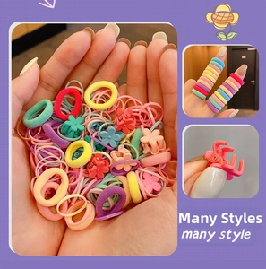 Detail showing macaron color hair elastics and floral claw clips for kids and girls