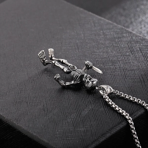 Macro shot of gothic dual skeleton pendants holding daggers in vintage steel finish