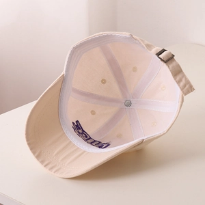Détail de l'intérieur d'une casquette en toile avec boucle réglable et broderie violette