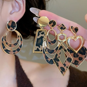 Close-up of leopard print hollow round earrings and golden geometric studs for women