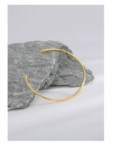 Detail of 14K gold plated silver open cuff on grey stone with cubic zirconia settings
