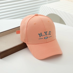 Detailed embroidery of NYC 21 on a peach cotton baseball cap with soft lighting
