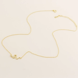 Macro detail of gold snake pendant with sparkling stones on minimalist chain