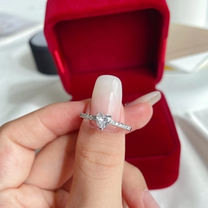 Macro shot of silver S925 heart-shaped ring with zircon stones in a red jewelry box