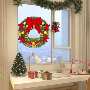 Cosy Christmas wreath with red bow and ornaments hanging on window in warm room