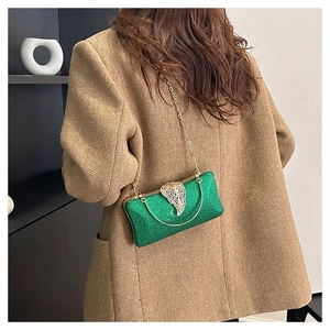 Detailed back view of green sequined evening bag with golden leaf clasp and chain strap