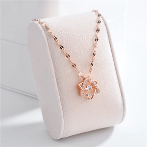 Rose gold stainless steel necklace with a moving star pendant on a beige jewelry pillow