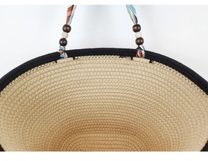 Detailed close-up of woven straw bag texture with colorful ribbon and wooden beads