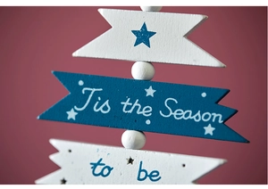 Detail of blue and white wooden holiday hanging ornaments with festive script and star motifs