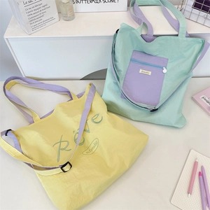 Macro shot of two-tone canvas tote bags with contrast straps and printed artistic lettering