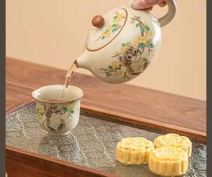 Ru-kiln ceramic teapot set featuring a cute cat and flower design pouring fresh tea