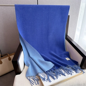 Detail view of double-sided cashmere scarf in navy and light blue with fringe and label
