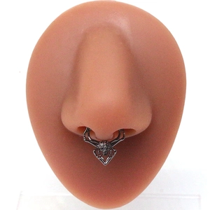 Silver spider septum ring with skull design on silicone nose model for body piercing