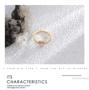 Detailed close-up of a gold-plated heart ring with pink zircon and white diamond accents