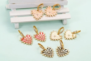 Macro shot of colorful enamel heart earrings with gold trim and sparkling zircon stones