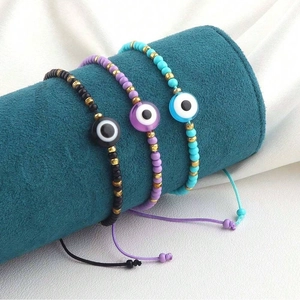 Detailed view of adjustable evil eye bracelets in black, purple and light blue beads