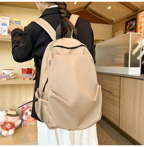 Detail of a minimalist beige backpack with adjustable side drawstrings and large capacity