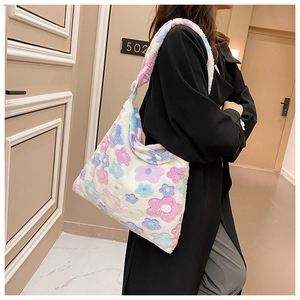 Detailed view of plush white floral tote bag with soft pink and blue flower patterns