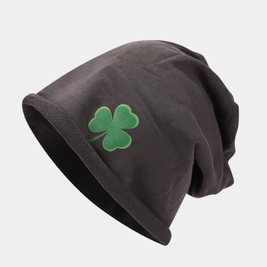 Dettaglio del berretto in maglia grigio scuro con ricamo di trifoglio verde cucito