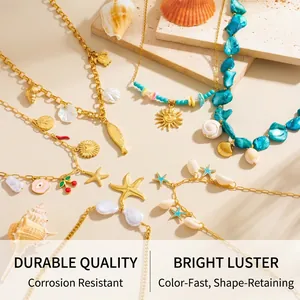 Detail of gold ocean themed necklaces with starfish and shell charms on sandy background