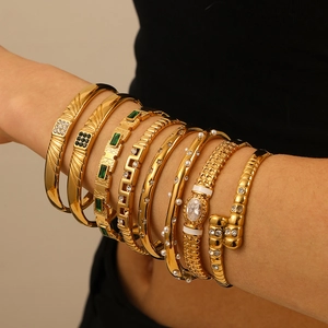Ensemble de bracelets en acier doré 18 carats avec gemmes vertes et émail blanc sur le poignet