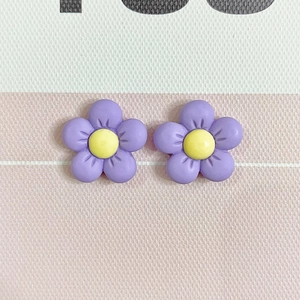 Detailed macro view of purple resin five-petal flowers with yellow stamens for DIY crafts