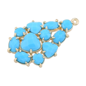 Detail of leaf-shaped grape pendant with blue stones and gold-plated copper base