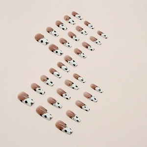 Medium length coffin press-on nails with nude gradient and black white cow print patterns