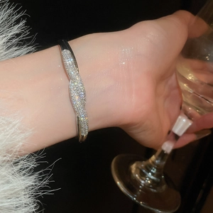 Détail macro du bracelet noeud argenté serti de zircons brillants sur un mannequin