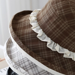 Close-up of plaid fabric texture and double-layered white lace trim on sun hats