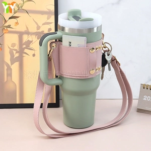 Detail of mint green tumbler with pink faux leather sleeve and adjustable strap