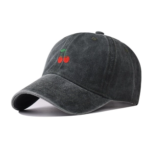 Close-up of red cherry embroidery on a dark grey washed cotton baseball cap