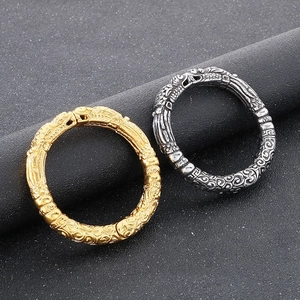 Close-up of retro dragon cloud pattern relief on gold and silver vintage cuff bracelets
