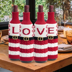 Detalle de fundas tejidas para botellas LOVE con hebillas de cinturón en mesa de fiesta