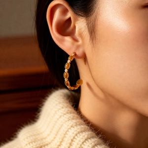 Détail des boucles d'oreilles en C plaquées or 18 carats avec pierres ambrées sur modèle
