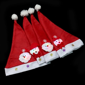 Set of four LED glowing Christmas hats with Santa Claus and snowman dolls on black background
