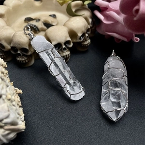 Detail of clear quartz crystal hexagonal pillar pendant with intricate silver wire wrapping