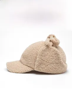 Vue latérale de la casquette beige en laine d'agneau avec polaire et protège-oreilles