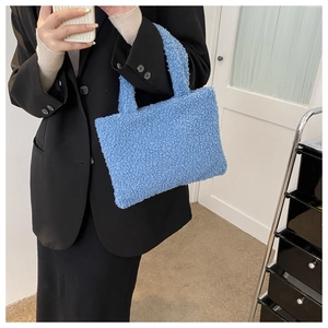 Detail showing a soft blue plush handbag held by a model for a stylish autumn look