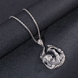 Retro stainless steel necklace with tiger animal pendant on black textured background