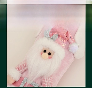 Detail of pink velvet Christmas stocking featuring sequin santa claus and 3D plush trim