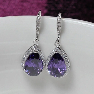 Macro shot of purple teardrop cubic zirconia earrings with halo sparkle detail