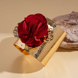 Close-up of red velvet flower on a brushed gold metallic cuff bracelet for women