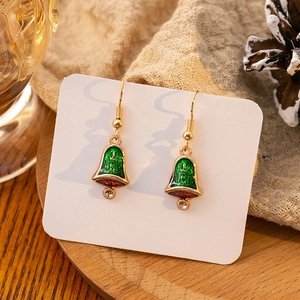 Macro shot of green and red enamel bell earrings with gold hooks and sparkling rhinestones