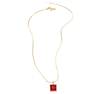 Détail d'un collier doré avec pendentif en zircon rouge carré et accents de petits diamants