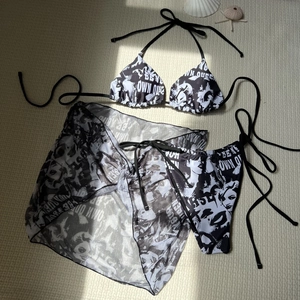 Detailed view of 3-piece bikini set with portrait print and sheer mesh skirt cover-up
