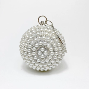 Close-up of spherical evening bag featuring white pearls, crystals, and silver ring handle