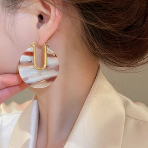 Gros plan sur des boucles d'oreilles en plaqué or 18k avec anneau en acétate marron